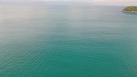 Aerial view of tranquil ocean with distant island and calm water surface Видео 342332972