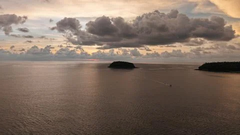 Aerial view of tranquil ocean with distant island and dramatic clouds Foto stock