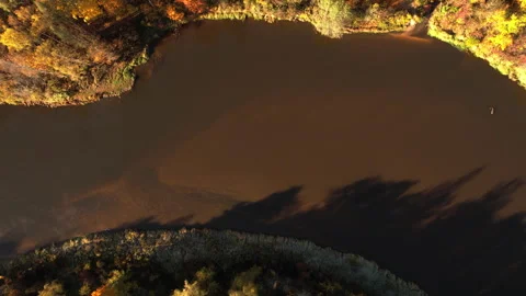 Aerial view of a tranquil river surrounded by autumn foliage Stock Footage 288674711