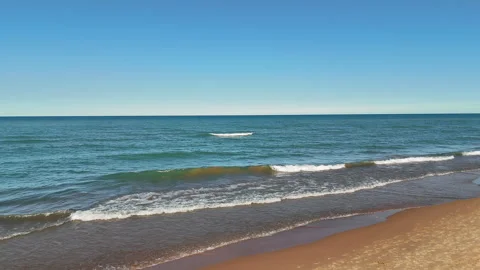 Aerial view Tranquil Sandy Beach and Calm Ocean Waves, Serene sea view with Stock Footage 299742124
