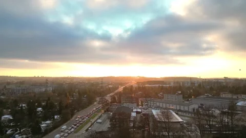 Aerial view transitions to a road with moving cars at sunset, capturing the Vidéo 335887166