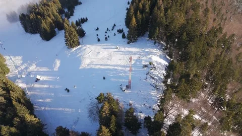 Aerial View of Transmitter Tower and Ski Slope in Winter Forest Stock Footage 336384266