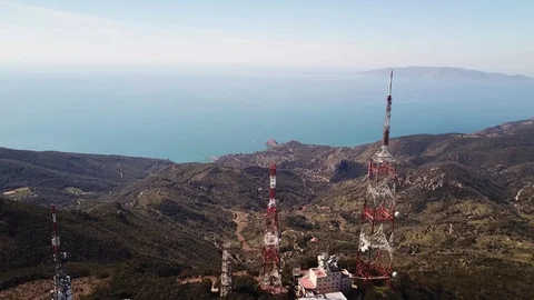 Aerial view, trellis structures on a peak with the seacoast at  distance Stock Footage 105241341