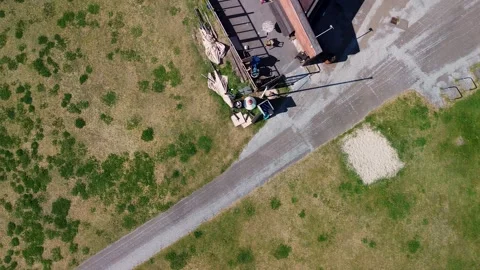 Aerial view of a triangular building near a beach, surrounded by grass, a road Stock Footage 310910210