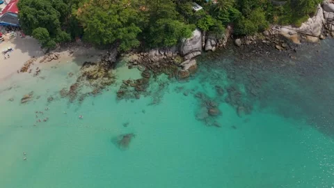 Aerial view of tropical beach with clear water and rocky shoreline Stock Footage 336926909