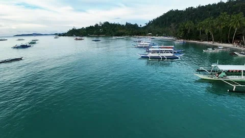 Aerial view of tropical coastline with multiple bangka boats in turquoise sea Vídeo Stock 319670294