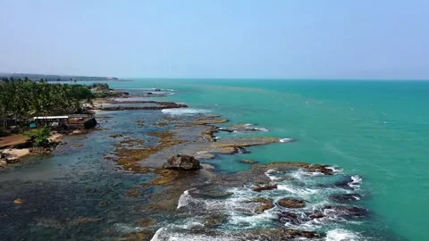 Aerial View of Tropical Ocean Waves Crashing on Rocky Shore Stock Footage 329456327