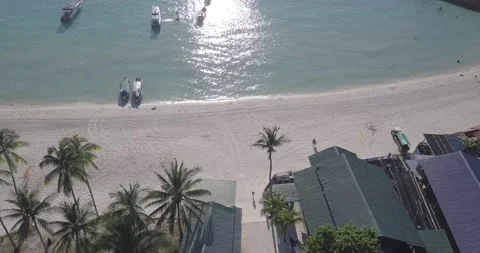 Aerial view of a tropical resort lead to an open sea, dolly in pan up slow Stock Footage