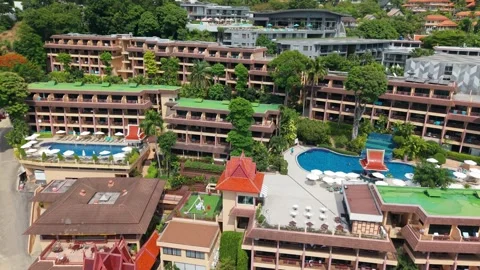 Aerial view of tropical resort with pools and lush greenery in background Видео 337418643