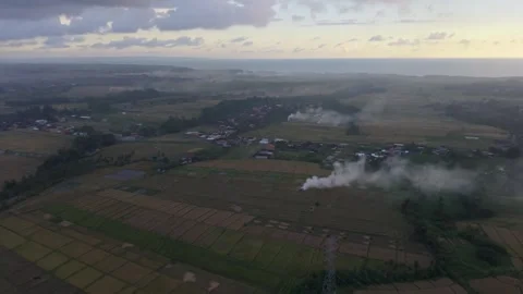 Aerial View of Tropical Rice Fields and Rural Village with Smoke at Sunset Stock Footage 338217054