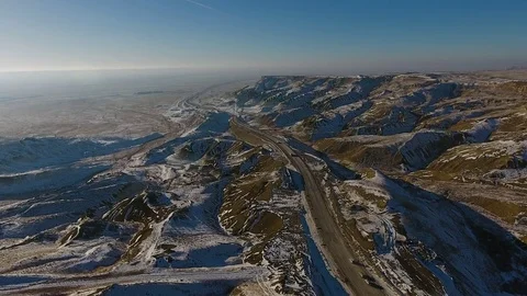 Aerial view of trucks and suvs moving along the highway in the desert in winter Stock Footage 80243501