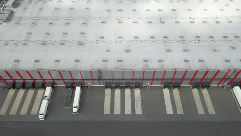 Aerial view of trucks backing into warehouse loading docks Stock Footage 342517571