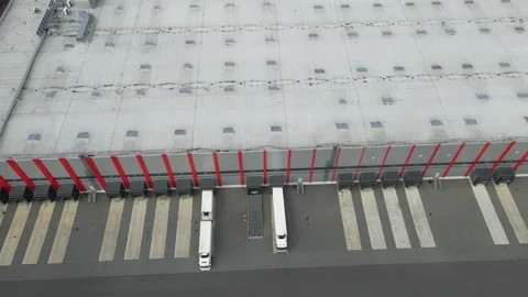 Aerial view of trucks loading at a modern industrial warehouse logistics center Stock Footage 343934491