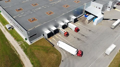 Aerial view of trucks unloading in logostics center Stock Footage 95421212