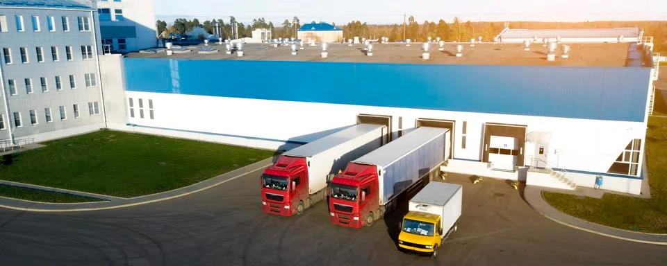 Aerial view of trucks unloading in logostics center. Stock Photos
