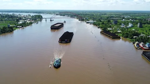 Aerial view of a tugboat pulling a barge filled with coal in the waters of .. Stock Footage 313063652