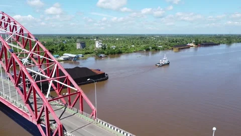 Aerial view of a tugboat pulling a barge filled with coal across the Rumpia.. Stock Footage 313095747