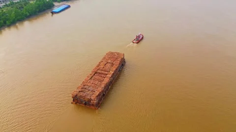 Aerial view of a tugboat pulling a log barge on Mahakam River, Indonesia. Stock Footage 345052096