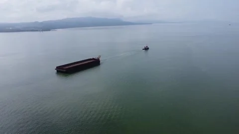 Aerial view of a tugboat towing an empty barge in the Kalimantan sea Stock Footage 267544671
