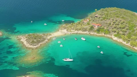Aerial view of a turquoise bay with several yachts and boats anchored near the Stock Footage 346696325