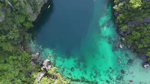 Aerial View of a Turquoise Lagoon Surrounded by Lush Cliffs Stock Footage 295791622