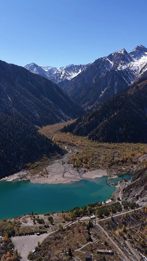 Aerial view of turquoise mountain Issyk's lake and snowy peaks, Kazakhstan Stock Footage 344756472