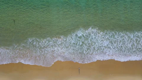 Aerial view of turquoise ocean wave reaching the coastline with tourist walking 스톡 동영상 170826344