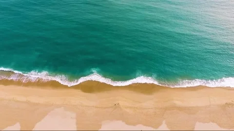 Aerial View of Turquoise Ocean Waves Crashing on a Sandy Beach Stock Footage 302308128