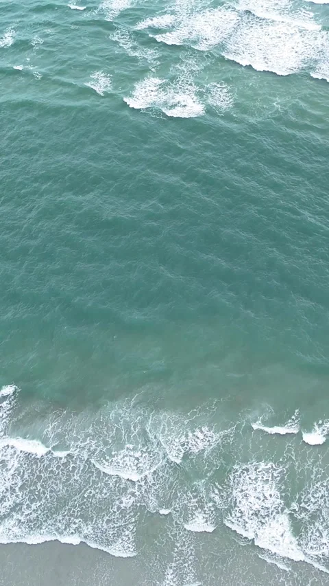 Aerial view of turquoise ocean waves crashing on sandy beach Stock Footage 323915079