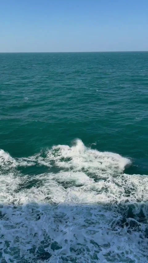 Aerial view of turquoise ocean waves crashing against the surface Vidéo 334353700