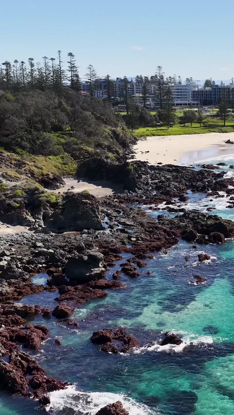 Aerial View of Turquoise Ocean Waves Crashing Against Rocky Shoreline Stock Footage 341854089