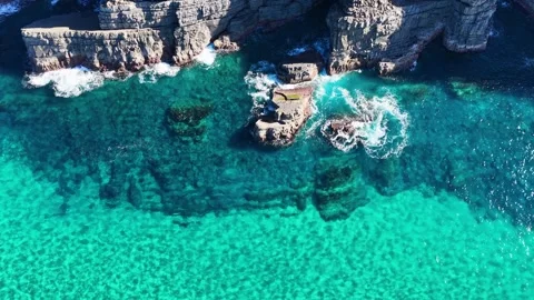Aerial View of Turquoise Ocean Waves Crashing Against Coastal Cliffs Video stock 342468758