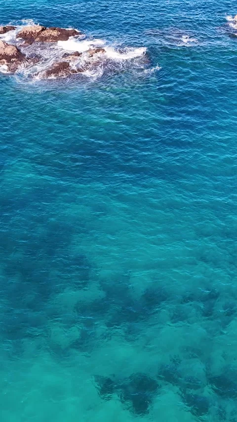 Aerial View of Turquoise Ocean Waves Crashing Against Rocks Video stock 342575759