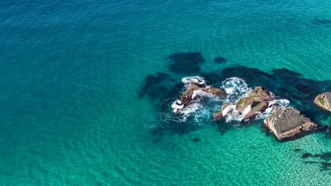 Aerial View of Turquoise Ocean Waves Crashing Against Rocks Video stock 342577040