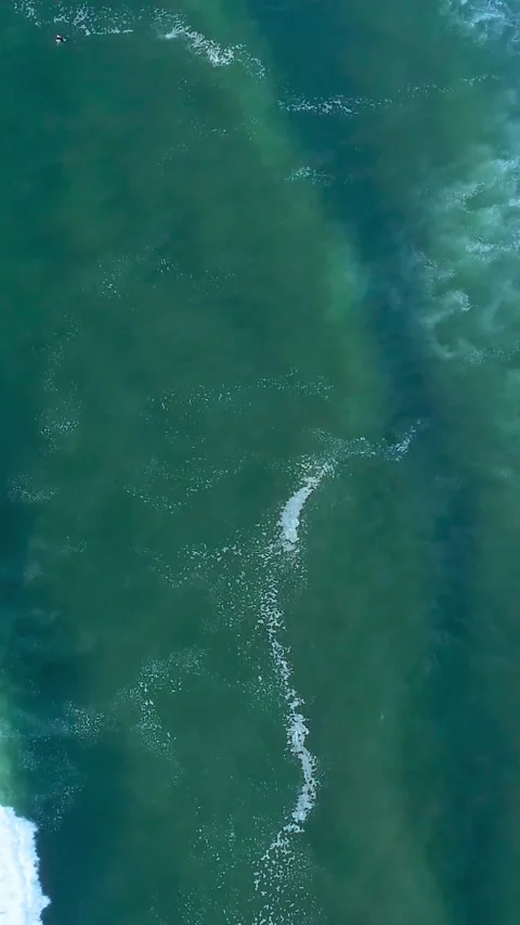 Aerial view of turquoise ocean waves crashing on the surface of the deep blue Stock Footage 347154609