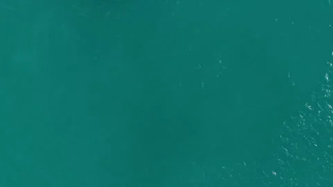 Aerial view of turquoise sea surface texture with a luxury white catamaran. Video stock 336757684