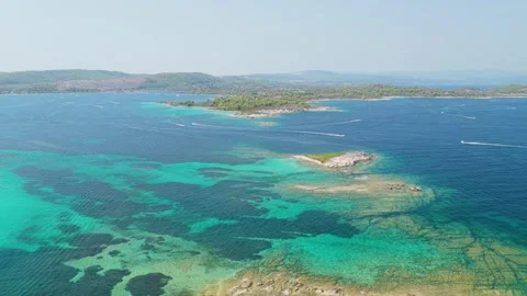 Aerial view of the turquoise waters and rugged coastline of Diaporos Island in Stock Footage 346719625
