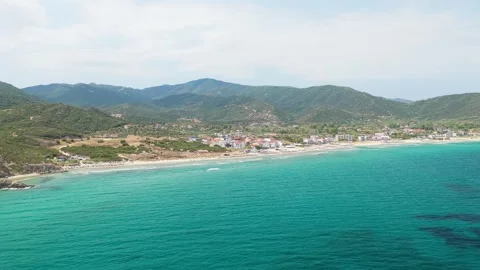 Aerial view of the turquoise waters and sandy shoreline of Sarti beach, with the Stock Footage 346721153