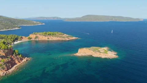 Aerial view of the turquoise waters, rugged coastline, and small rocky islet Stock Footage 346677094