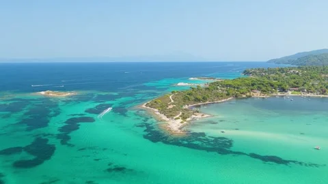 Aerial view of the turquoise waters, sandy coastline, and lush greenery of Stock Footage 346704205