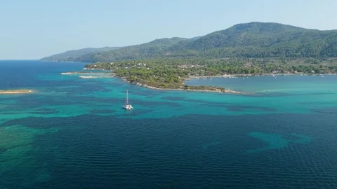 Aerial view of the turquoise waters, small islets, and lush green coastline of Stock Footage 346703361
