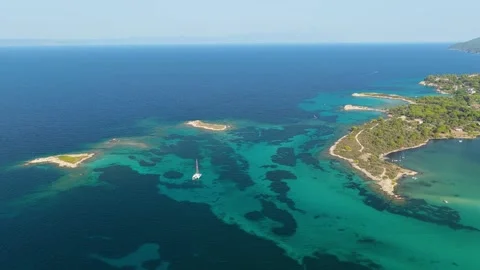 Aerial view of turquoise waters, small islets, and a sailing boat off the coast Stock Footage 346712285