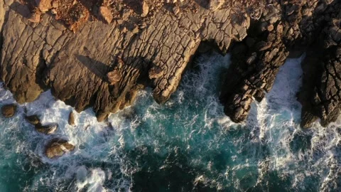 Aerial view of turquoise waves hitting rocky shore on Mediterranean island Stock Footage 168771737