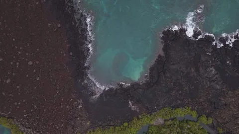 Aerial view of turquoise waves lapping dark volcanic rocks at Galapagos 스톡 동영상 308404943