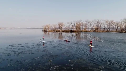 Aerial view of two athletes on the SUP and kayaker. Winter. Ice. Stock Footage 73296047