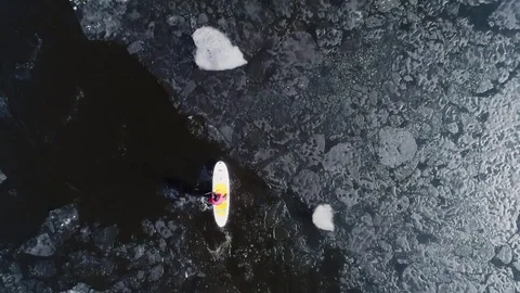 Aerial view of two athletes on the SUP. Winter. Ice. Slowmotion. Stock Footage 73296726