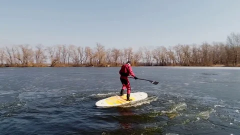 Aerial view of two athletes on the SUP. Winter. Ice. Slowmotion. Stock Footage 73297038