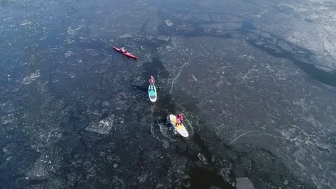 Aerial view of two athletes on the SUP and kayaker. Winter. Ice. Stock Footage 73297246