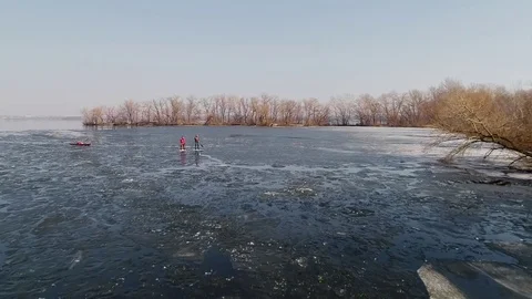 Aerial view of two athletes on the SUP and kayaker. Winter. Ice. Stock Footage 73297409