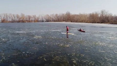 Aerial view of two athletes on the SUP and kayaker. Winter. Ice. Stock Footage 73297433